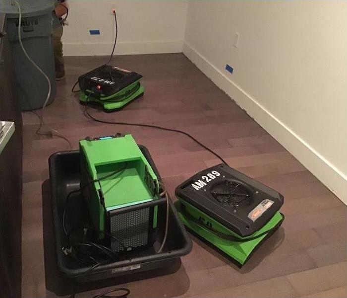 Green SERVPRO equipment sitting on a hardwood floor